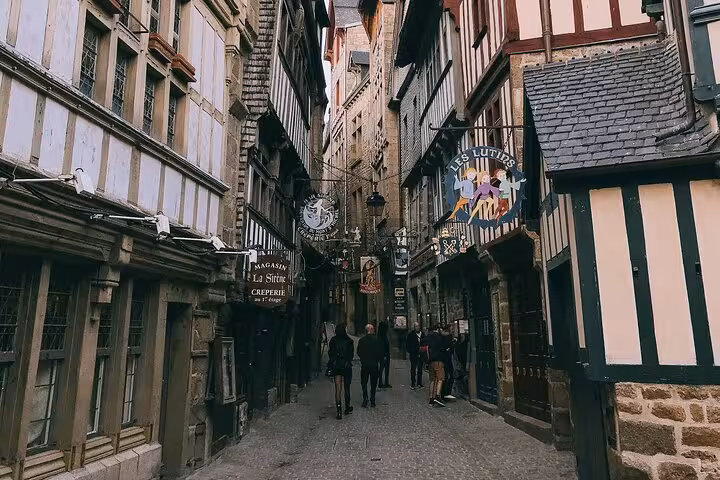 Narrow medieval street with half-timbered buildings and shops at Mont-Saint-Michel, France