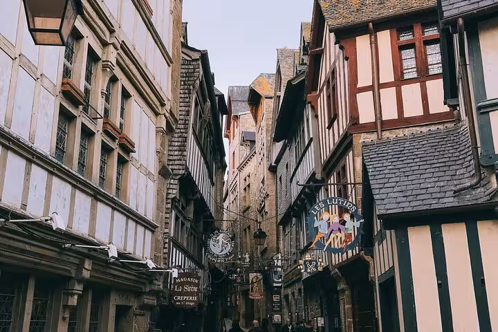 Medieval half-timbered buildings lining a narrow cobblestone street at Mont-Saint-Michel, Normandy, France