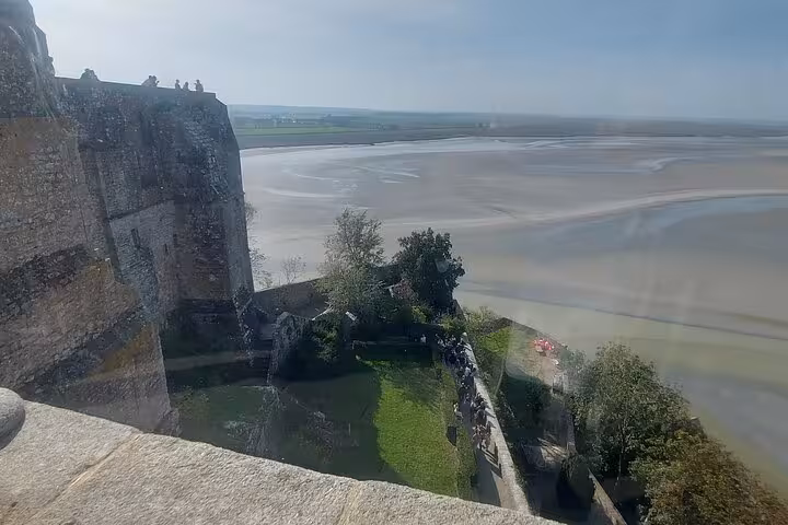 View from Mont Saint-Michel ramparts over tidal bay and causeway, highlight of small-group day trip by luxury van