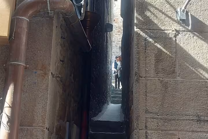 Narrow stone alley and steps in Mont Saint-Michel village, Normandy, on small group day trip with luxury van