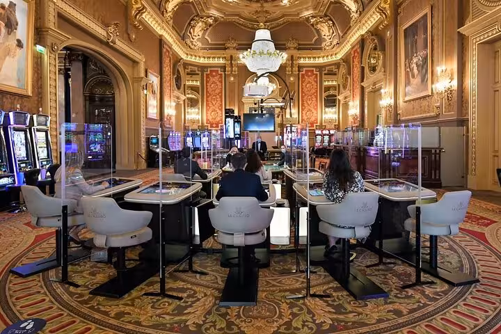 Elegant casino interior in Monte-Carlo, featuring opulent decor, gaming tables, and luxurious ambiance for a night tour.