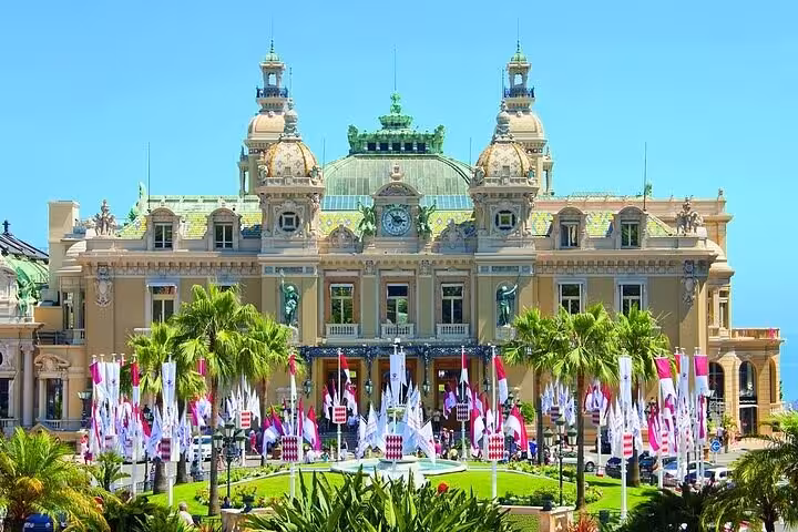Monte Carlo Casino ornate Belle Époque facade with palm trees and colorful flags on French Riviera