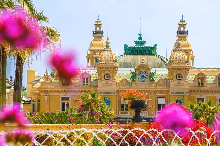 Ornate Belle Époque facade of Monte Carlo Casino with pink flowers and fountain in foreground, Monaco