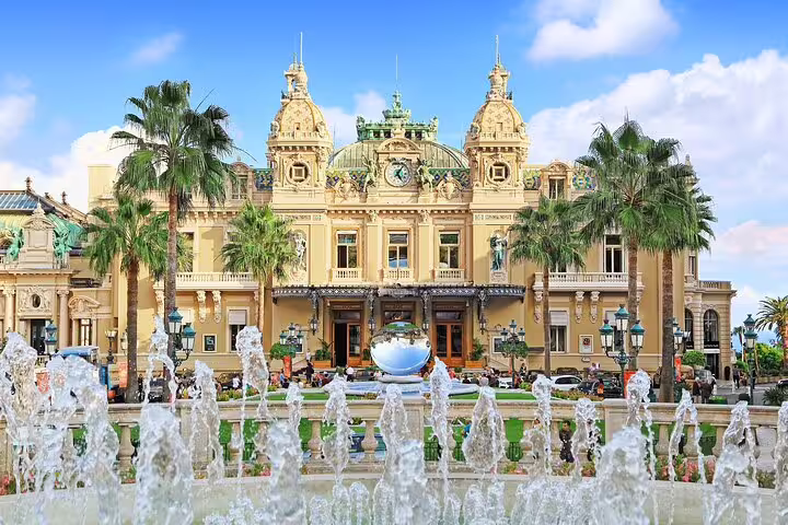 Monte Carlo Casino facade with ornate Baroque architecture, palm trees, and fountains in Monaco
