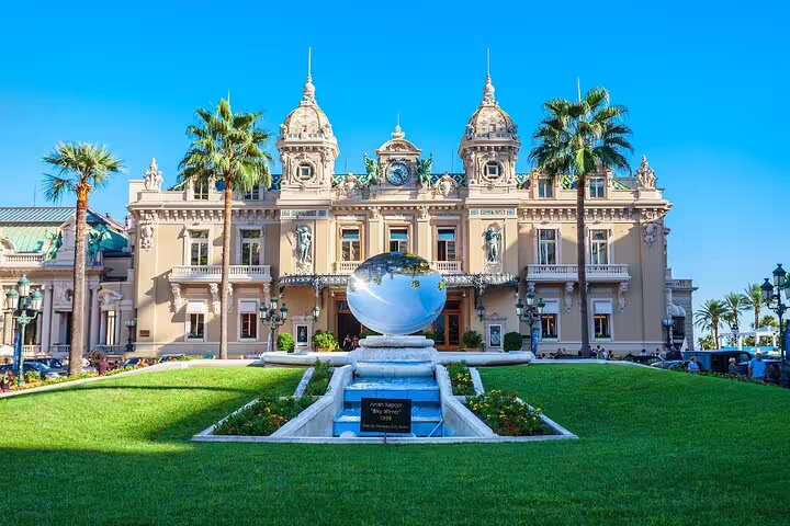Monte Carlo Casino facade with mirrored globe sculpture and manicured gardens, Monaco