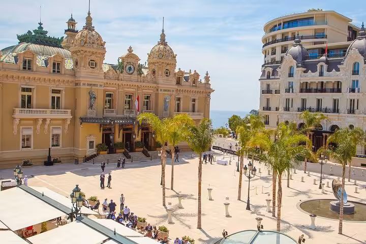Panoramic view of Monte-Carlo Casino Square with historic architecture and palm trees, perfect for a Monaco tour.
