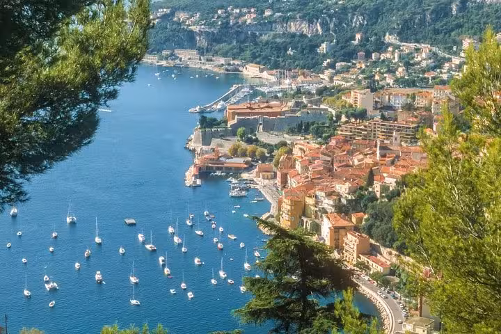 Scenic aerial view of Monte-Carlo's harbor with yachts and colorful buildings nestled along the azure coastline.