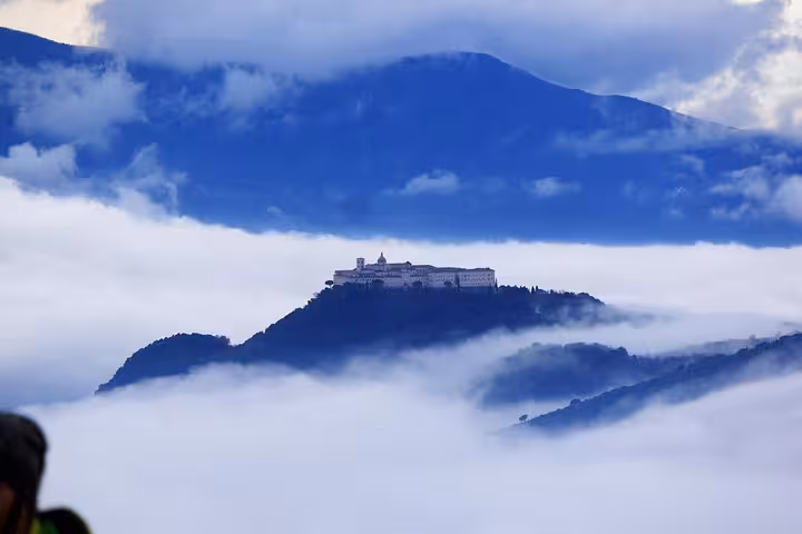 Monte Cassino Abbey rising above clouds on a misty mountain peak during a scenic WWII battlefield hiking tour