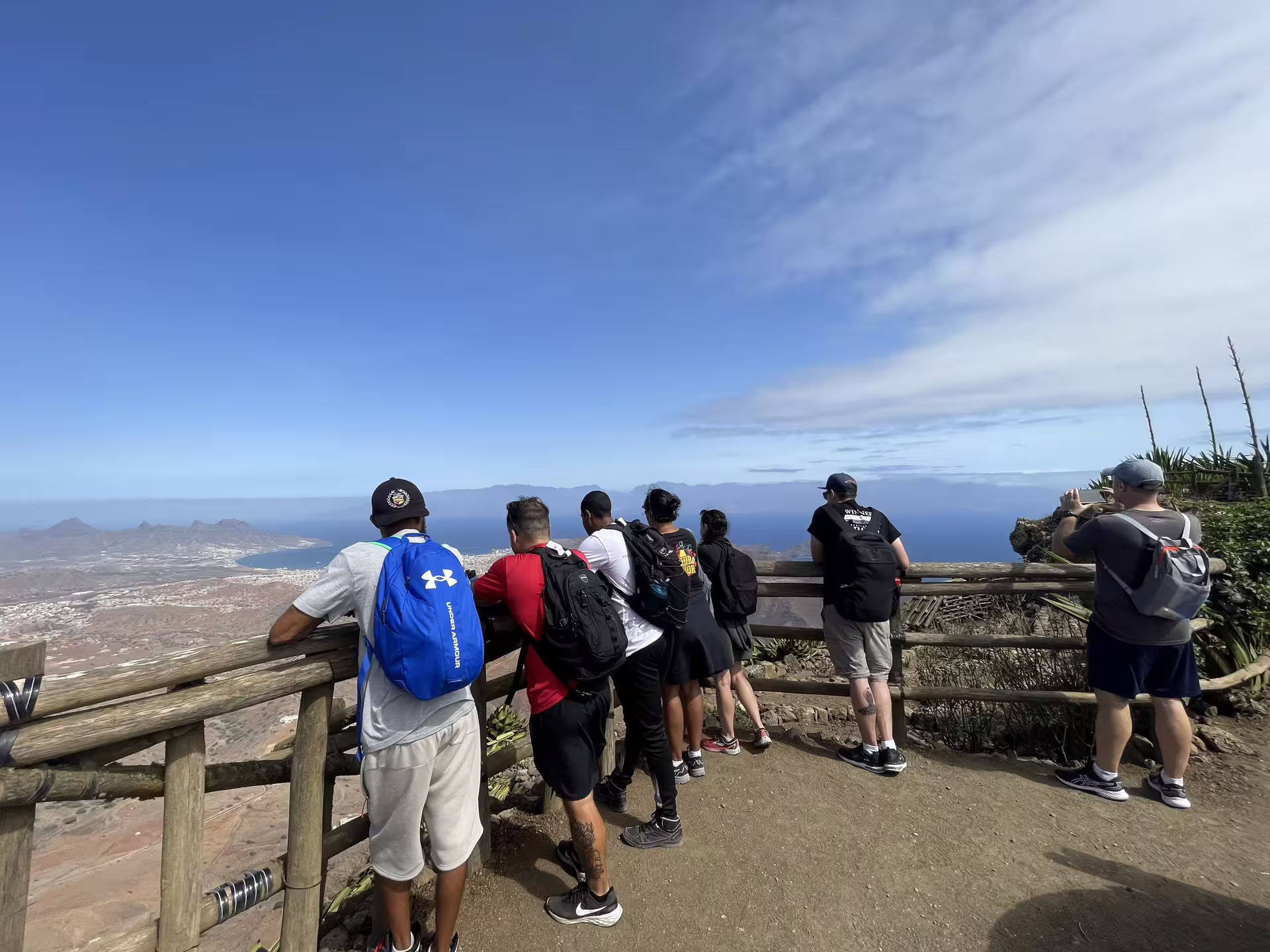 Group of hikers enjoying panoramic views from Monte Verde summit in São Vicente, Cape Verde, under a clear blue sky.