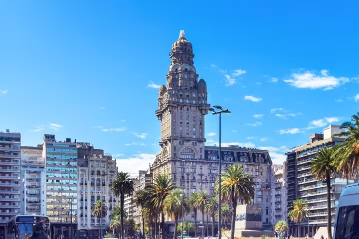 Palacio Salvo tower rising above Plaza Independencia with palm trees in Montevideo, Uruguay