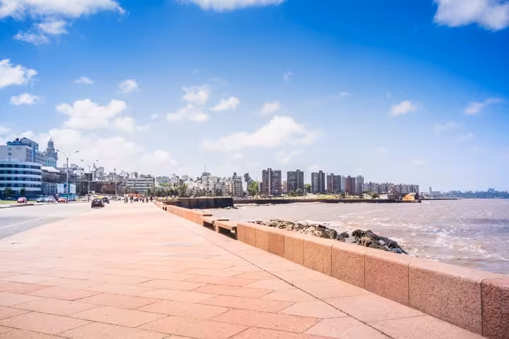 Montevideo waterfront promenade along the Río de la Plata with city skyline under blue sky