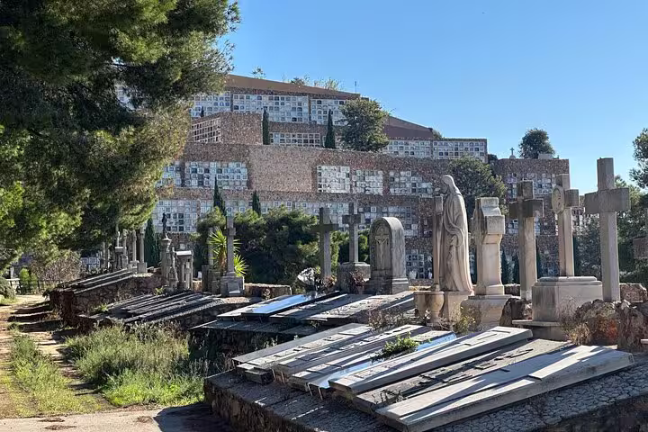 Explore Montjuïc Cemetery's intricate tombstones and serene pathways surrounded by lush greenery and historical architecture.