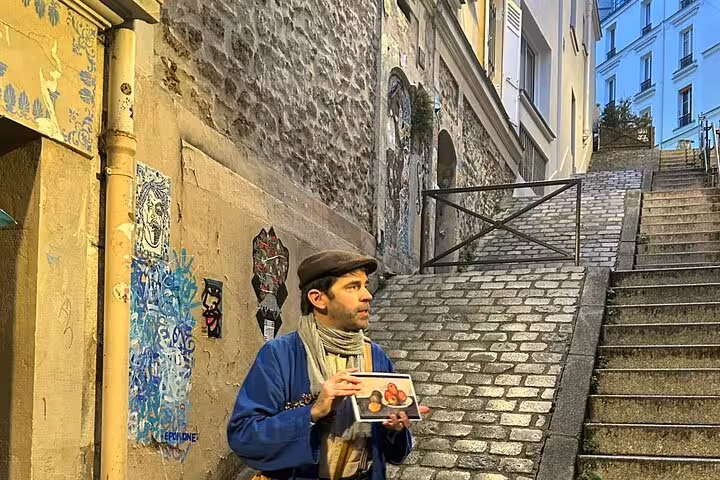 Artist holding a painting on cobblestone steps in Montmartre, Paris