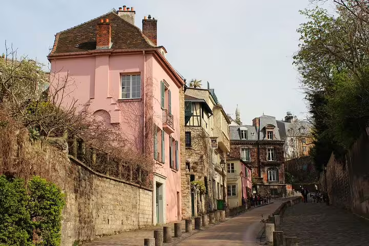 Charming cobblestone street in Montmartre with pink building and historic Parisian architecture