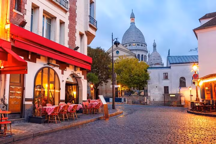 Evening Montmartre street with café terraces and Sacré-Cœur Basilica, Paris semi-private tour stop