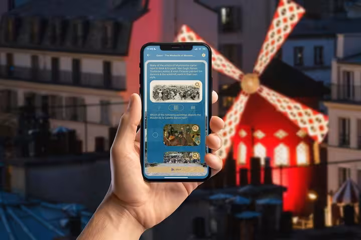 Montmartre GPS walking tour app displayed on smartphone with iconic Moulin Rouge windmill glowing red in Paris background
