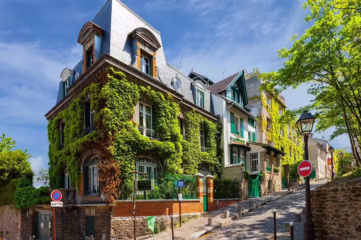 Ivy-covered historic buildings on a charming cobblestone street in Montmartre, Paris