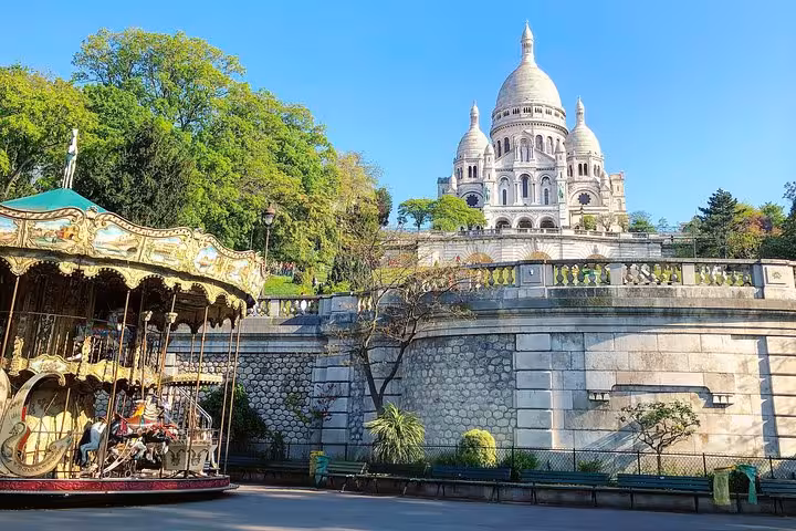 Sacré-Cœur Basilica rising above stone walls with a vintage carousel in Montmartre, Paris