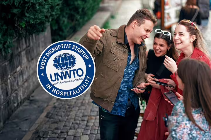 Guide pointing directions to tourists on cobblestone street in Montmartre Paris, UNWTO award badge visible