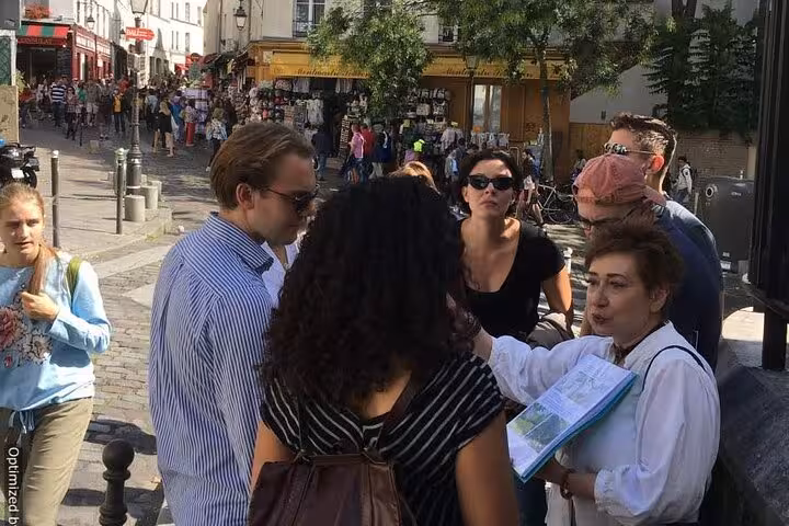 Small tour group exploring busy Montmartre streets in Paris during a self-guided GPS smartphone walking tour experience