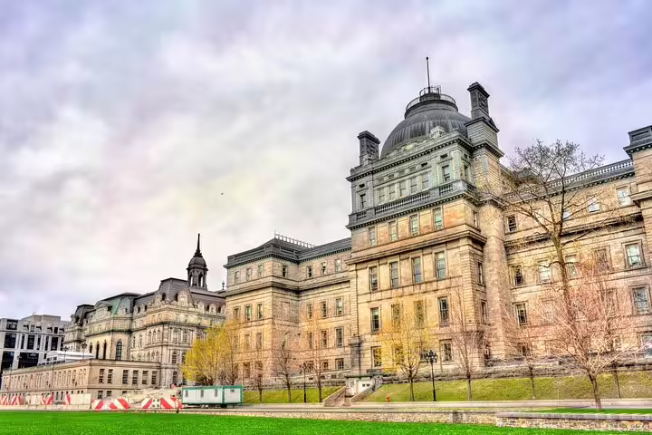 Historic stone buildings with domed roof in Montreal Old Town under cloudy sky