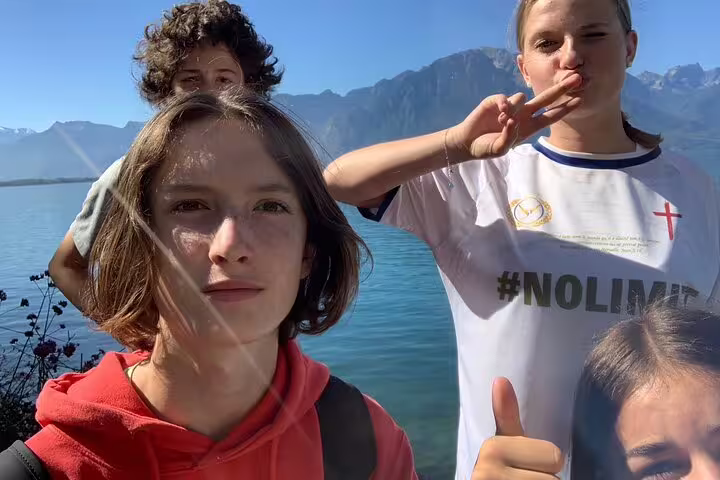 Teens by Lake Geneva in Montreux with Alps backdrop on a self-guided scavenger hunt and sightseeing walking tour