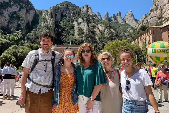 Group enjoying Montserrat private tour with La Moreneta access, stunning mountain backdrop, and convenient hotel pickup.