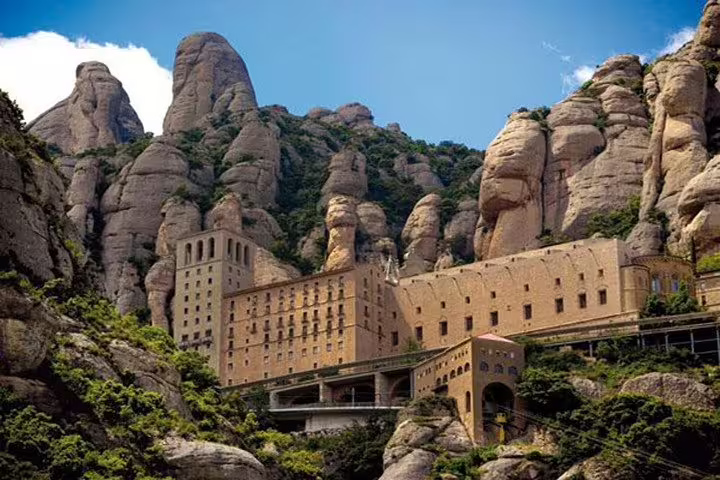 Scenic view of Montserrat Monastery nestled against the dramatic rocky cliffs of the mountain.