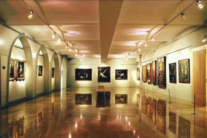 Elegant art gallery with arched ceilings and classic paintings, offering a cultural experience on the Montserrat tour.