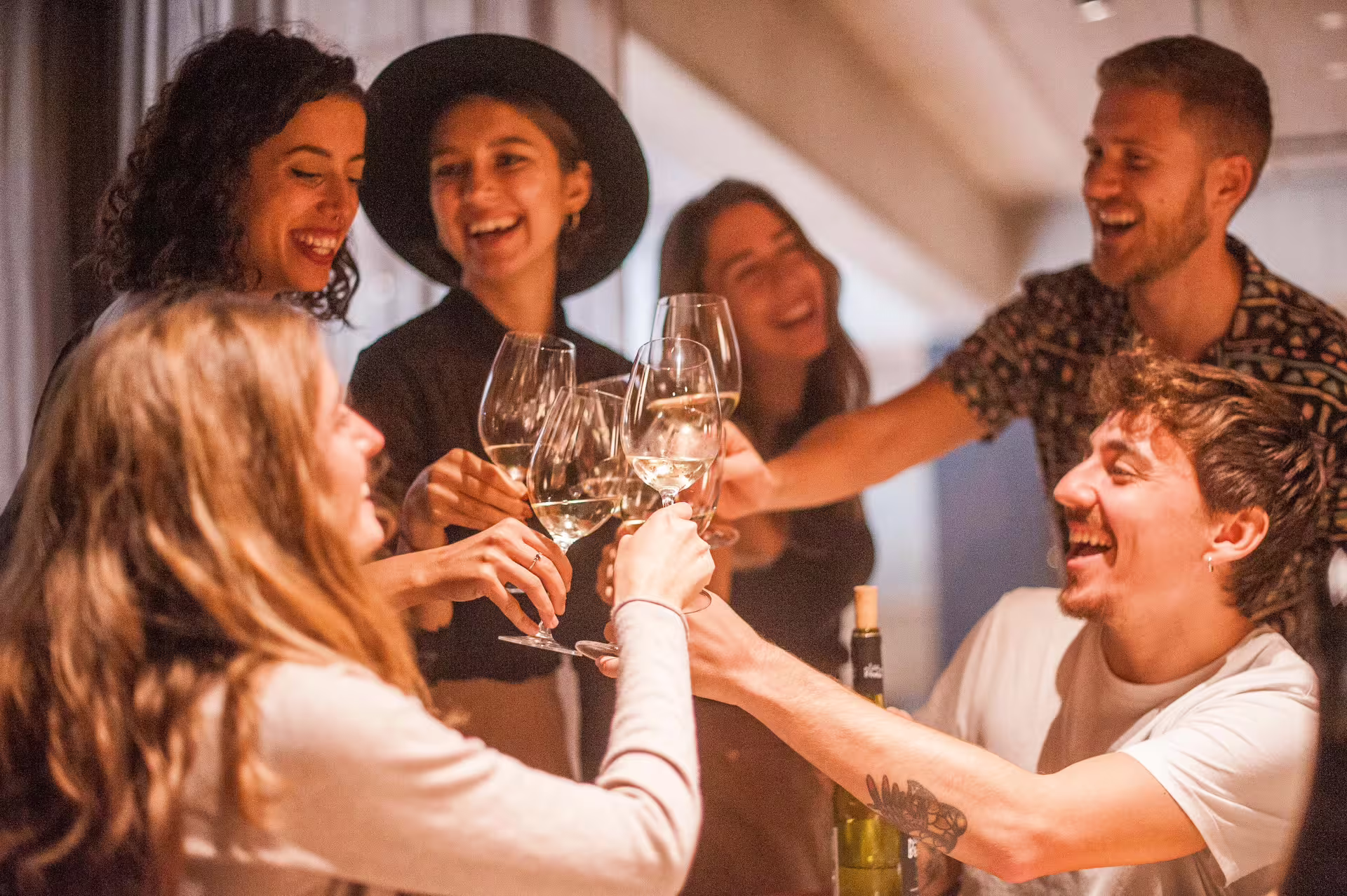 Group of friends toasting wine glasses, enjoying Montserrat's wine tasting experience.