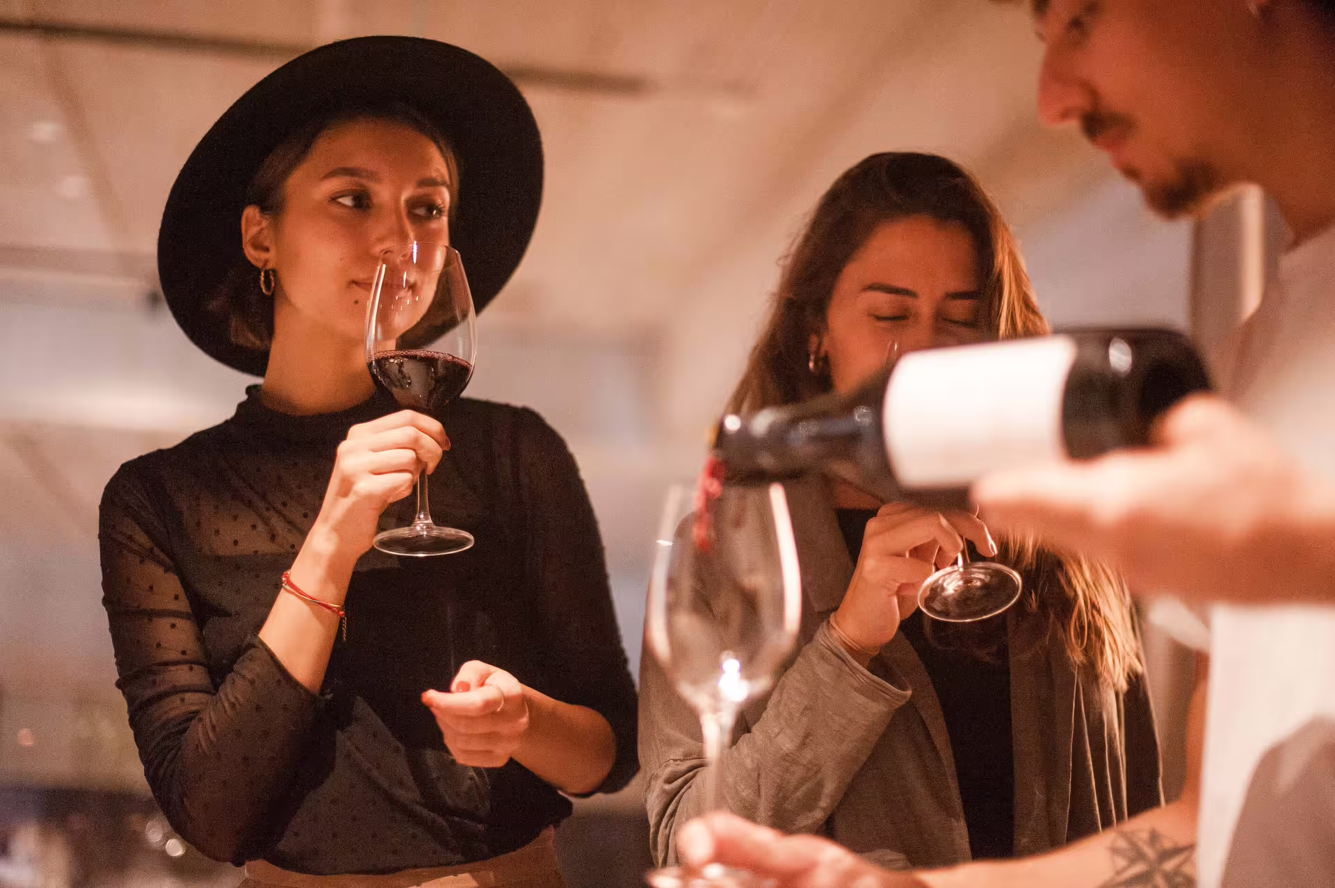 Guests enjoying a wine tasting experience during the Montserrat Tapas & Wine tour, savoring fine red wine.