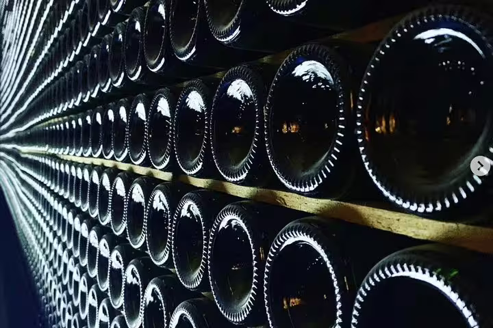 Rows of wine bottles in a dimly lit cellar, showcasing the allure of a Montserrat organic winery visit.