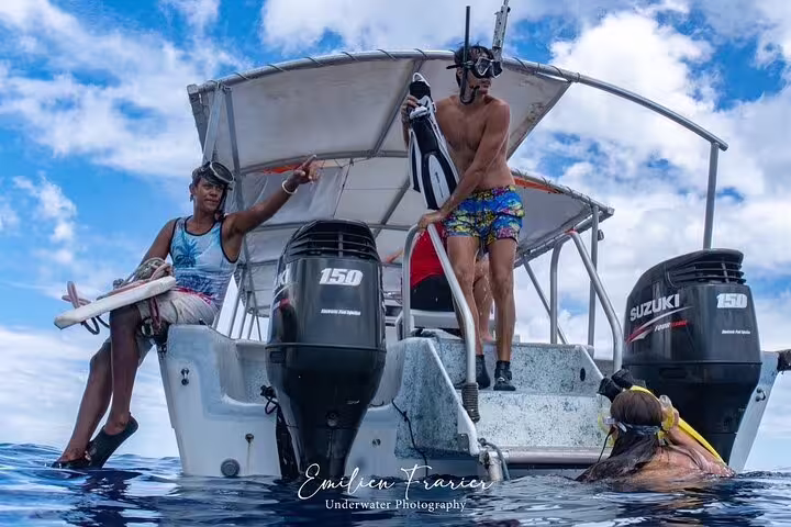 Snorkelers boarding a boat with twin 150hp Suzuki outboard motors in Moorea, French Polynesia