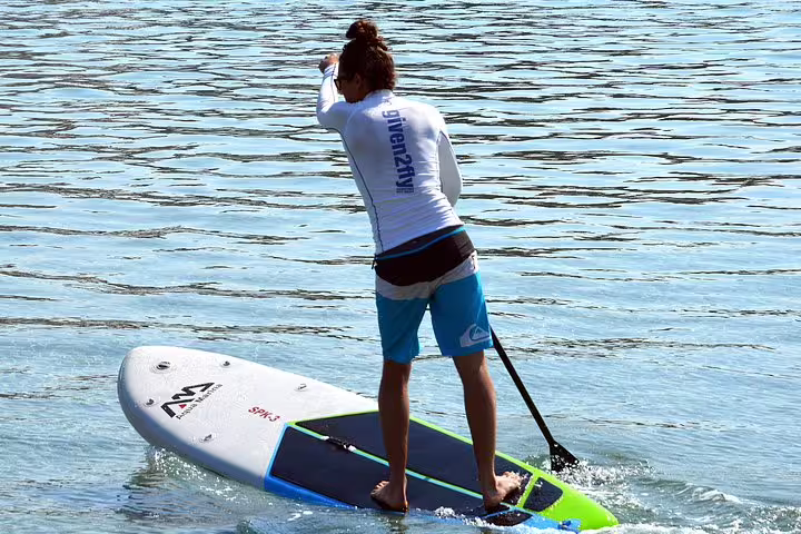 Paddler standing on SUP in calm sea during a morning stand up paddle tour in Split, Croatia coastline