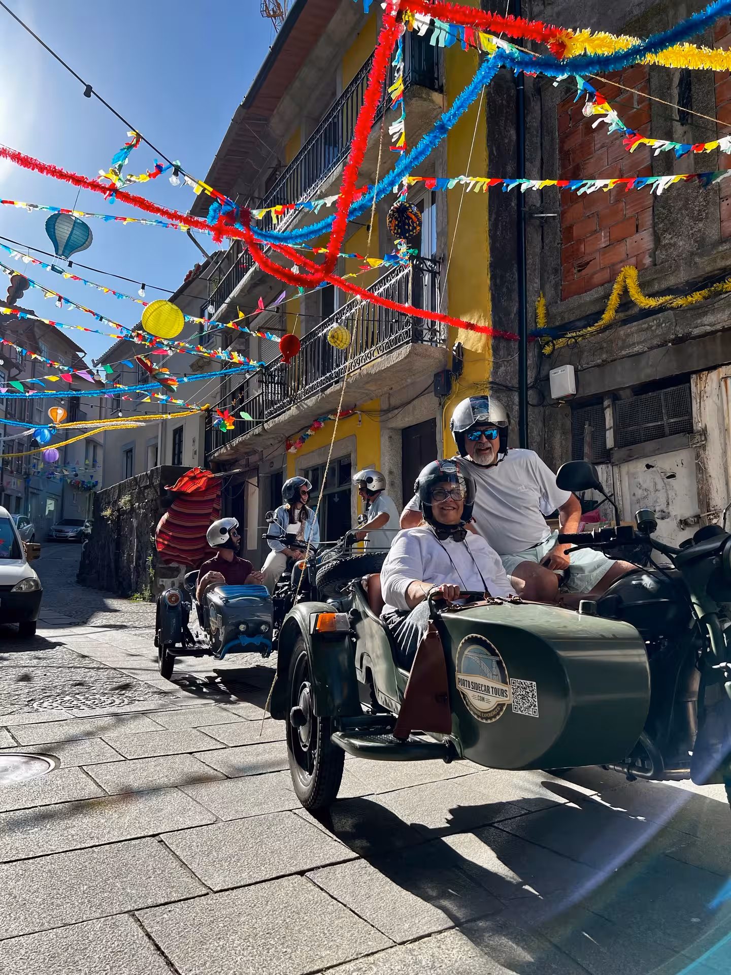 Morning Tour Porto sidecar convoy through decorated Porto street with festive ribbons and local neighborhood views