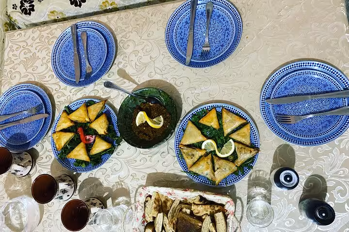 Traditional Moroccan meal spread with pastries, dips, and drinks on an elegantly set table in Yassine's cooking class.