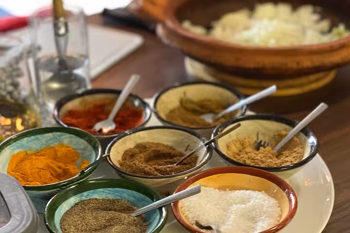 Array of Moroccan spices in small bowls ready for use in a Marrakesh sardine tawa cooking class.