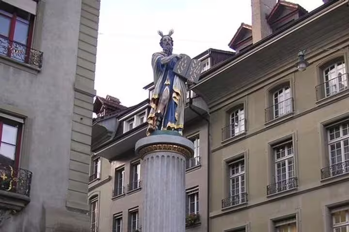 Colorful medieval Moses fountain statue atop stone column in historic European city square