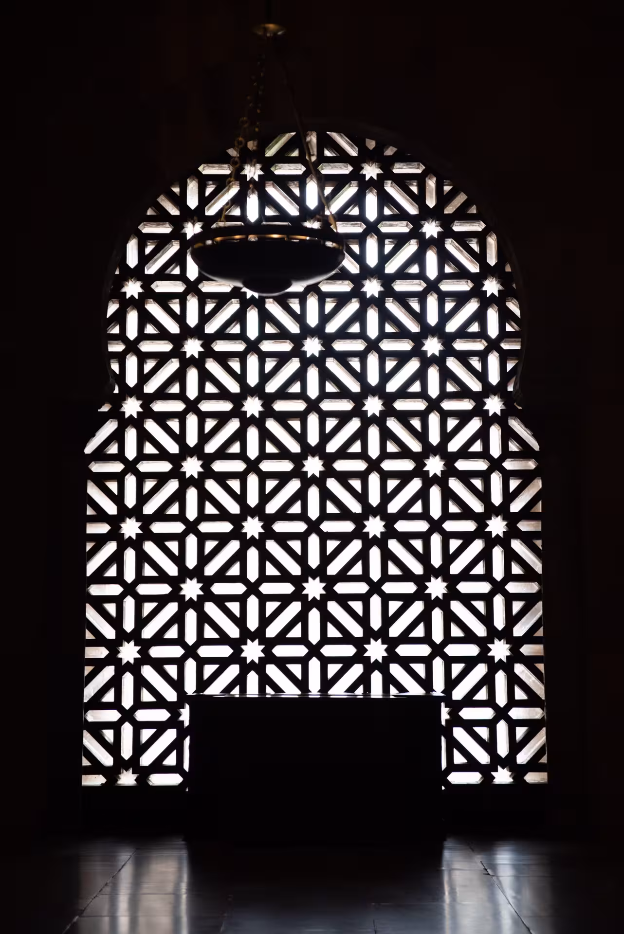 Marvel at the intricate geometric patterns of the ornate window inside the Mosque-Cathedral of Córdoba, Spain.