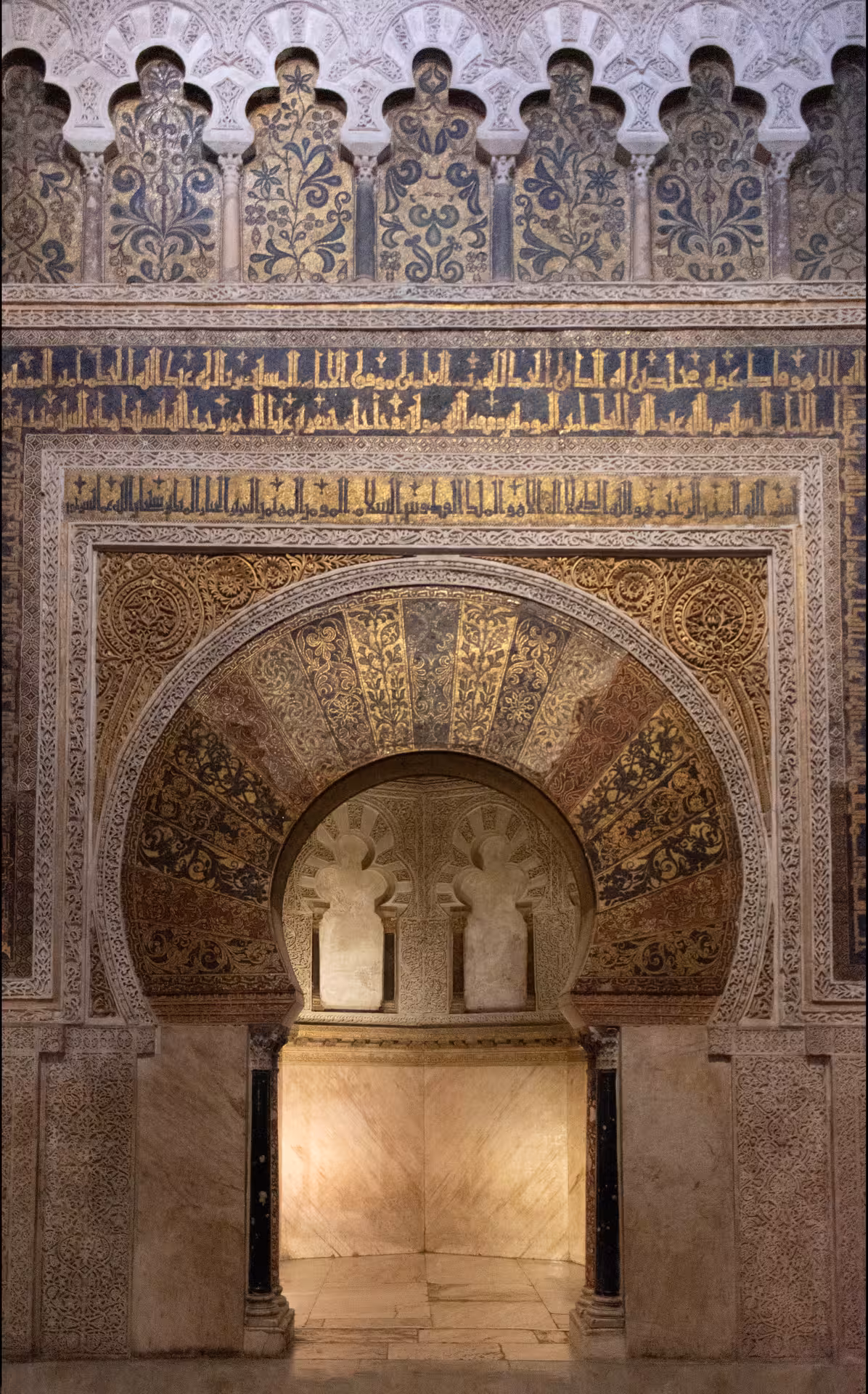 Intricate Islamic architectural details inside the Mosque-Cathedral of Córdoba featuring Arabic calligraphy.
