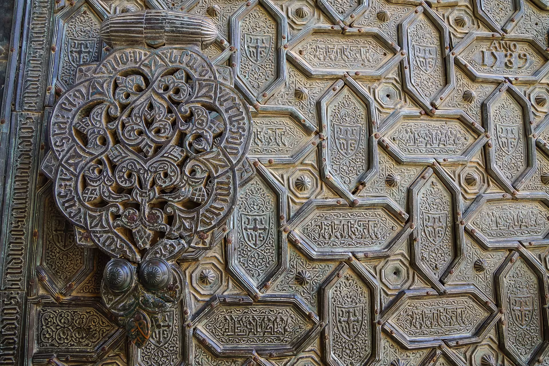 Close-up of ornate Arabic calligraphy and patterns on the historic door of the Mosque-Cathedral of Córdoba.