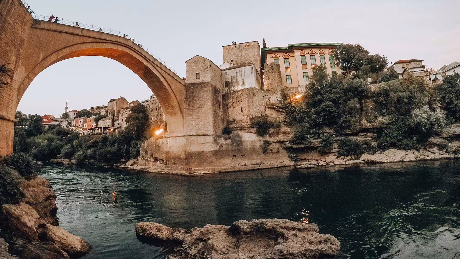 Mostar Old Bridge at sunset over the Neretva River, highlight stop on the Day Trip to Mostar & Kravice Waterfalls