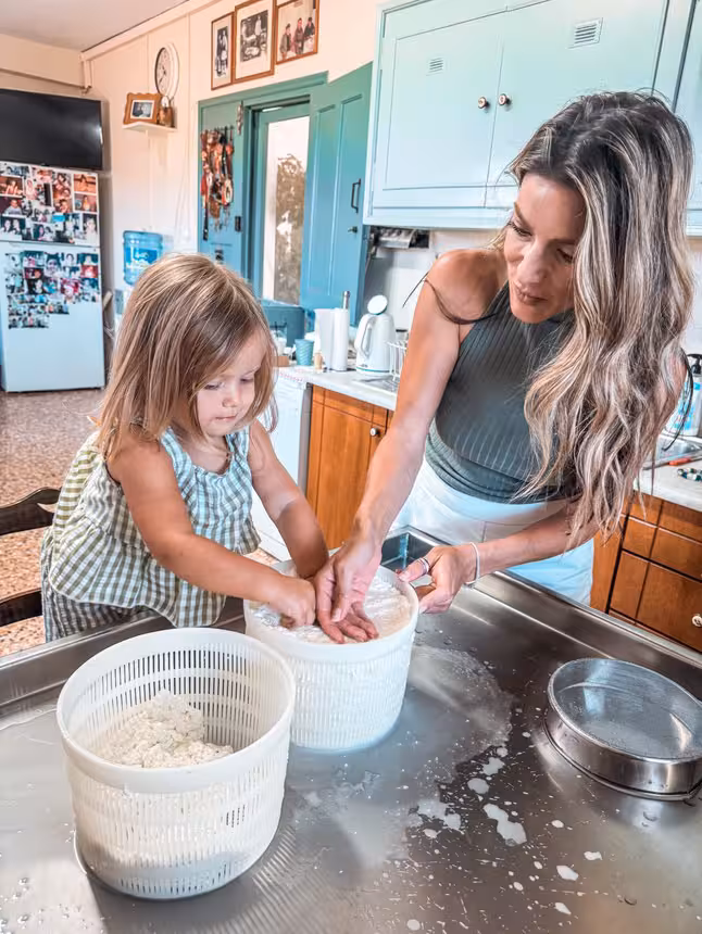Mother and child making fresh cheese at a farmhouse kitchen table, Kids First hands-on family cooking activity