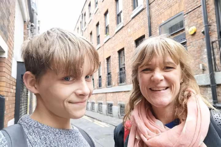 Smiling woman and child on a Manchester street with brick buildings in the background