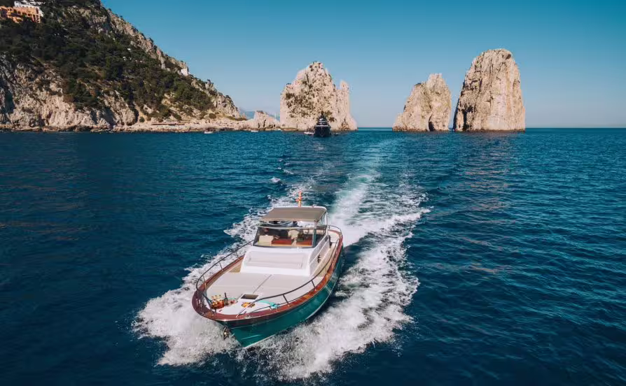 Motorboat sailing from Amalfi toward Capri’s Faraglioni rocks on a scenic Li Galli and Capri islands day trip in Italy