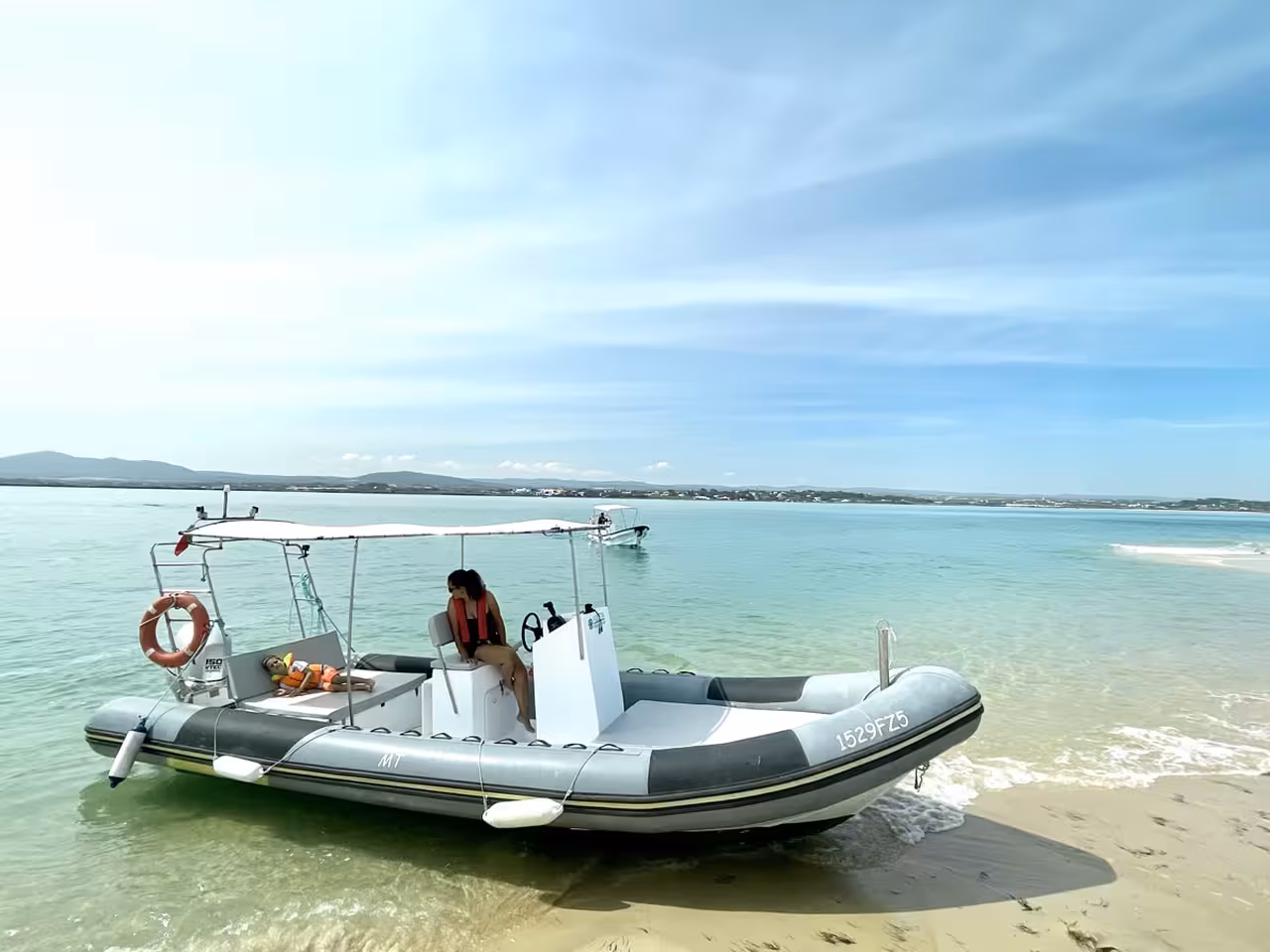 Spacious motorboat rental docked on a sandy Cabanas de Tavira beach ideal for groups up to 11 passengers