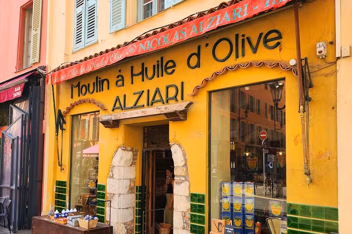 Charming yellow facade of Moulin à Huile d'Olive Alziari, a traditional olive oil shop in the French Riviera.