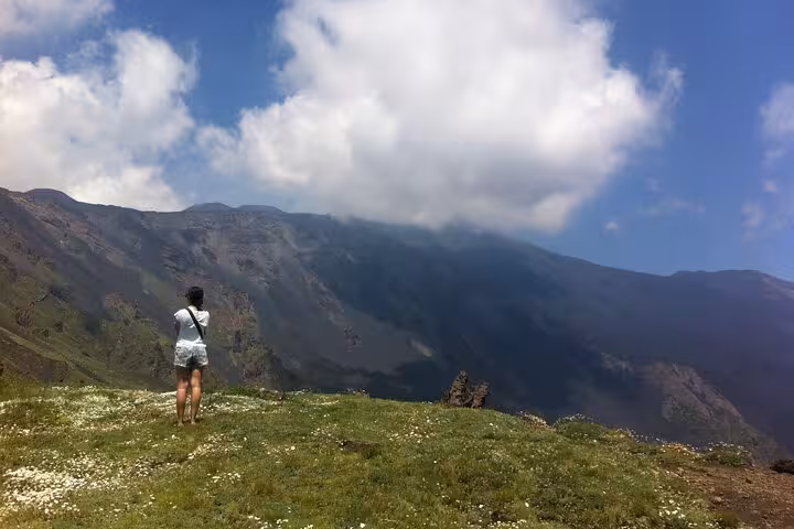 Solo traveler captures stunning view of Mount Etna's lush slopes and dramatic clouds on Etna Sunset Tour.