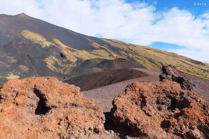 Experience the vibrant volcanic terrain of Mount Etna under a clear sky on the Etna and Taormina Tour, departing at 08:30.