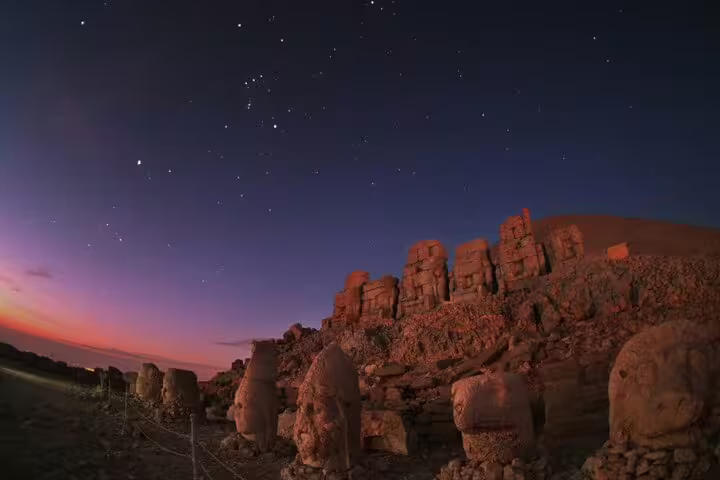 Mount Nemrut summit statues at twilight under starry sky, highlight of private Turkey tour from Cappadocia